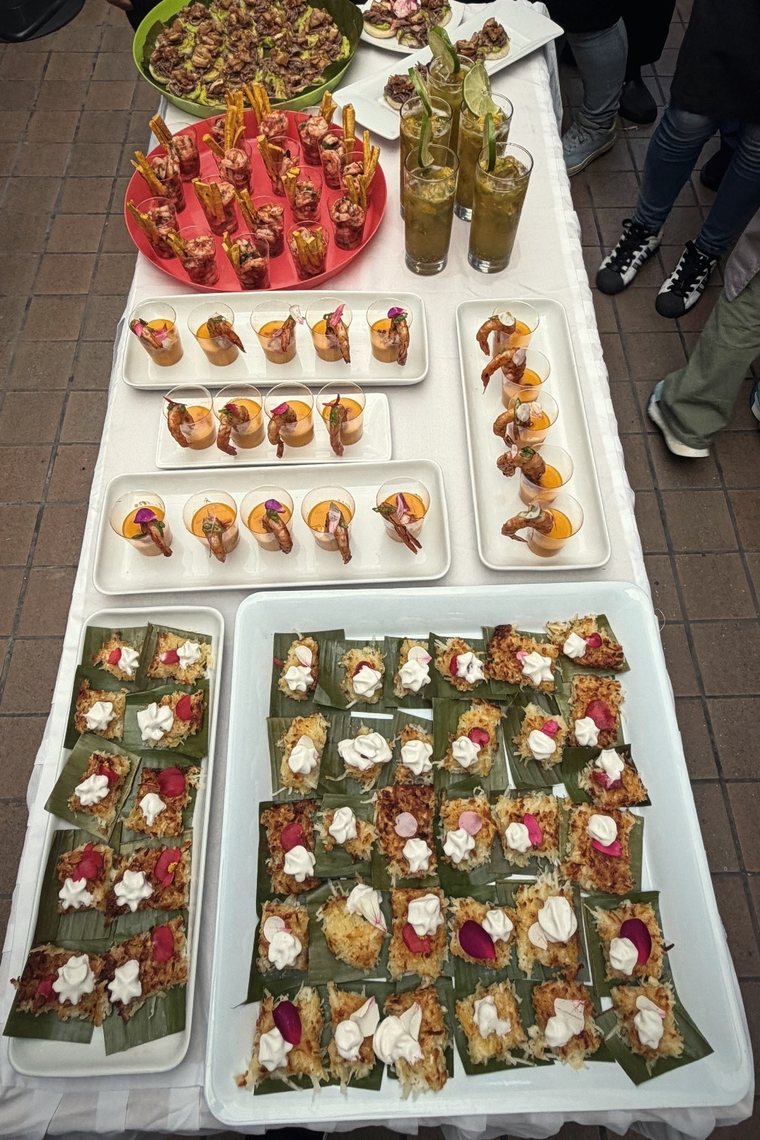 Mesa larga con bandejas de pasabocas, ceviches y coctelería.